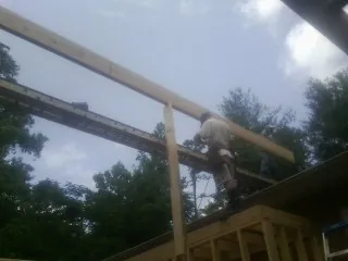 Carpenter setting a ridge beam over a new addition frame — Ice Dam Removal by Roofing Brothers in Alameda