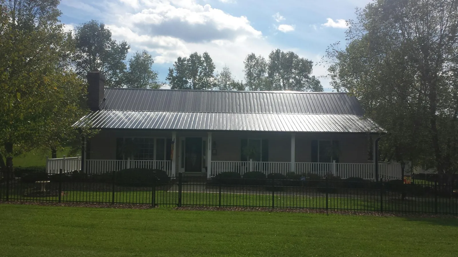 Gray metal roof on a brick ranch with a full width front porch — Gutter Guard Installation work by our crew in Alameda